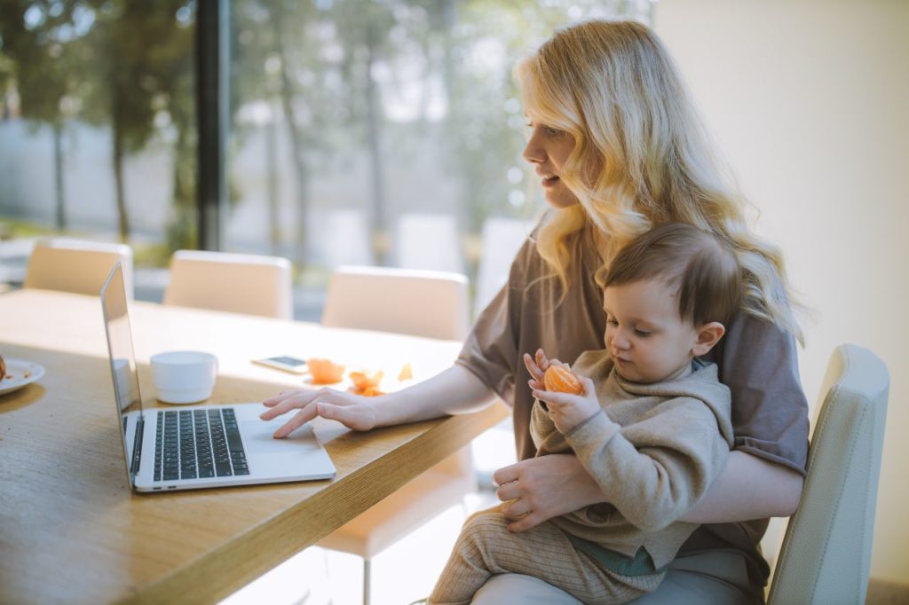 woman holding a baby while working