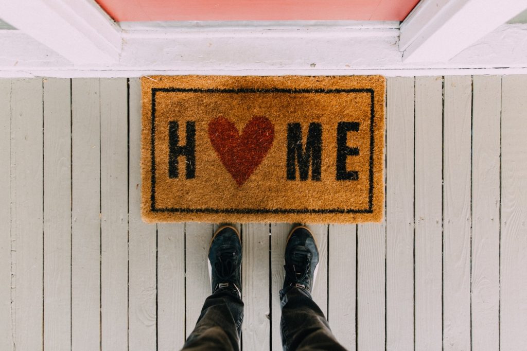 man standing next to a doormat