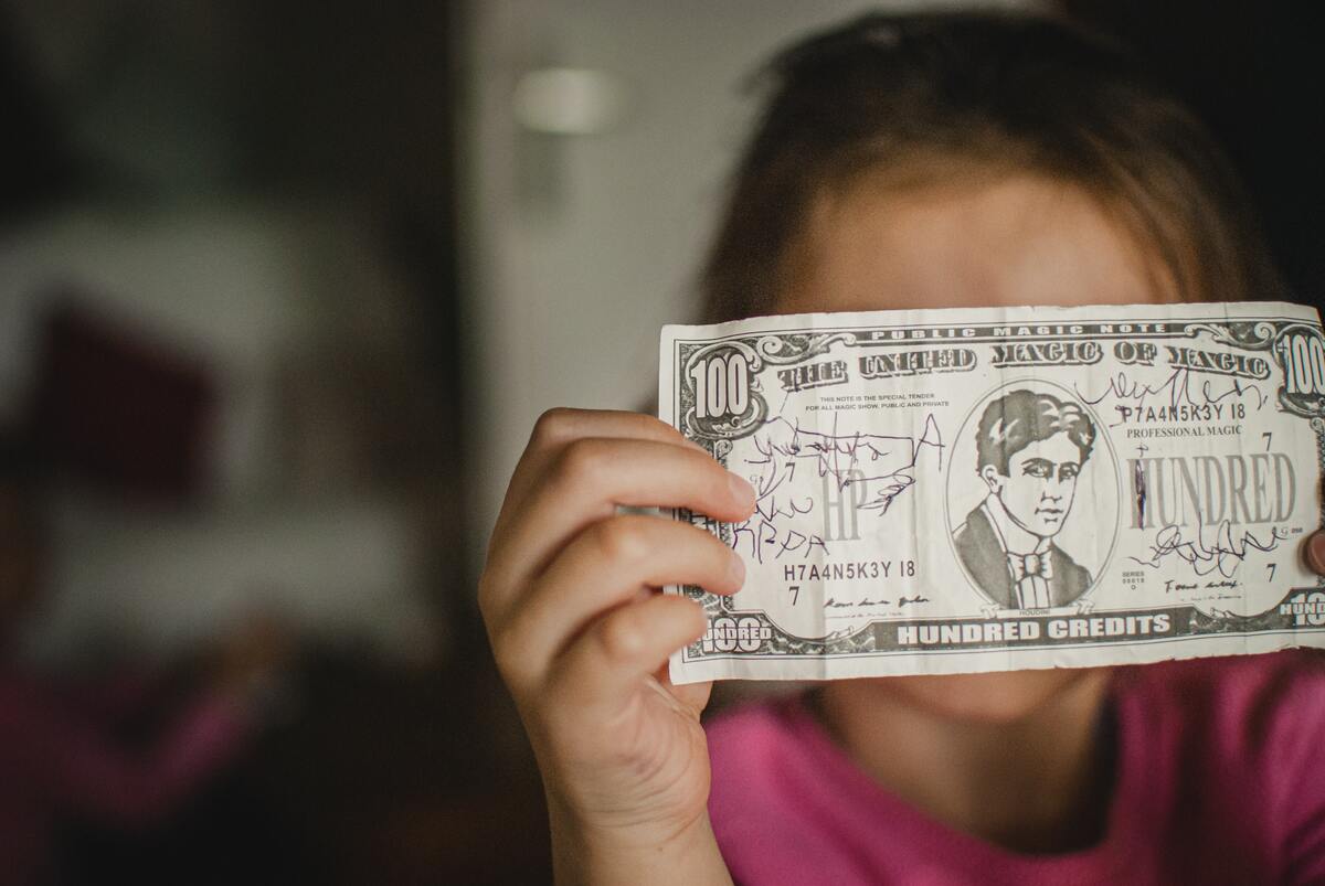 kid showing her drawing in a fake bill