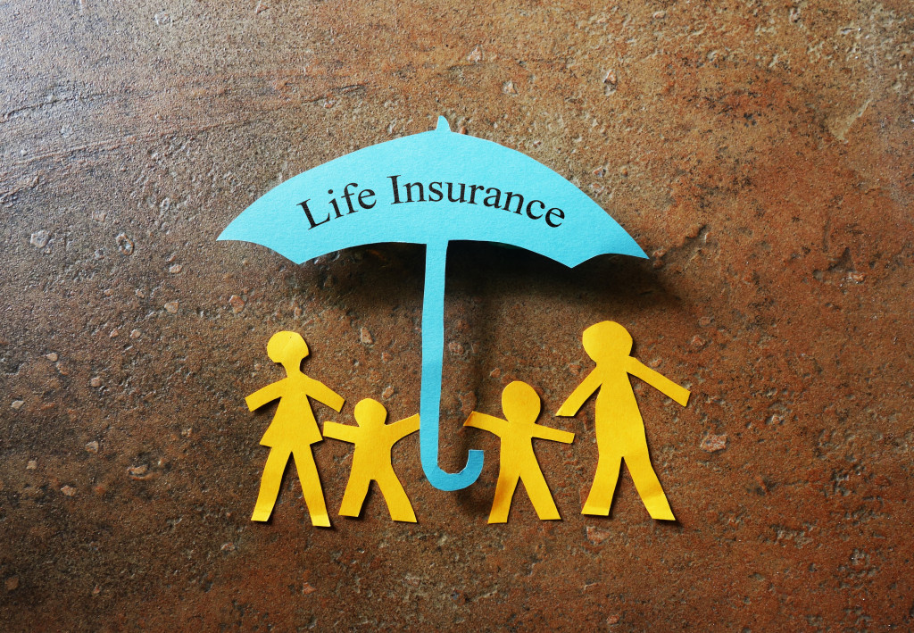 Paper cutouts of a family of four and an umbrella with the phrase Life Insurance