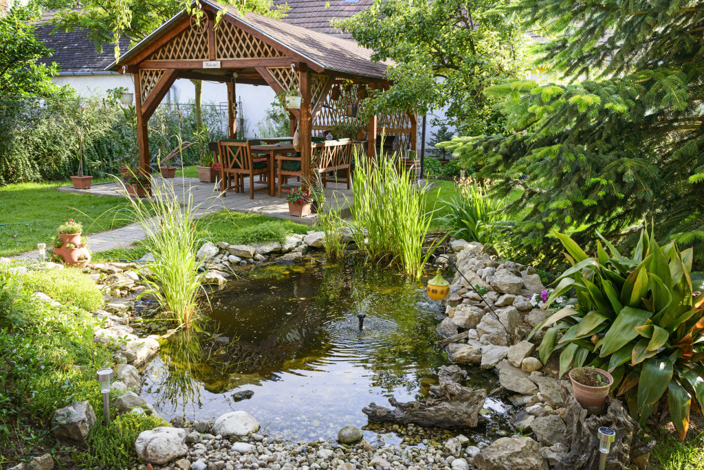 a beautiful garden with a bench and a little pond where people can relax