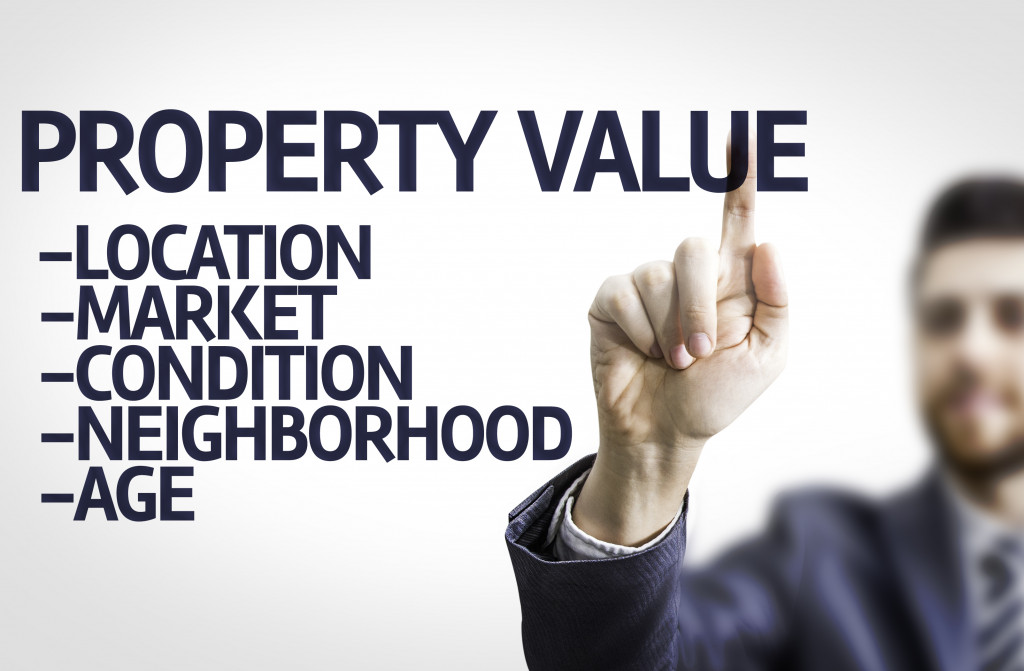 Business man pointing to transparent board with text: Property Value