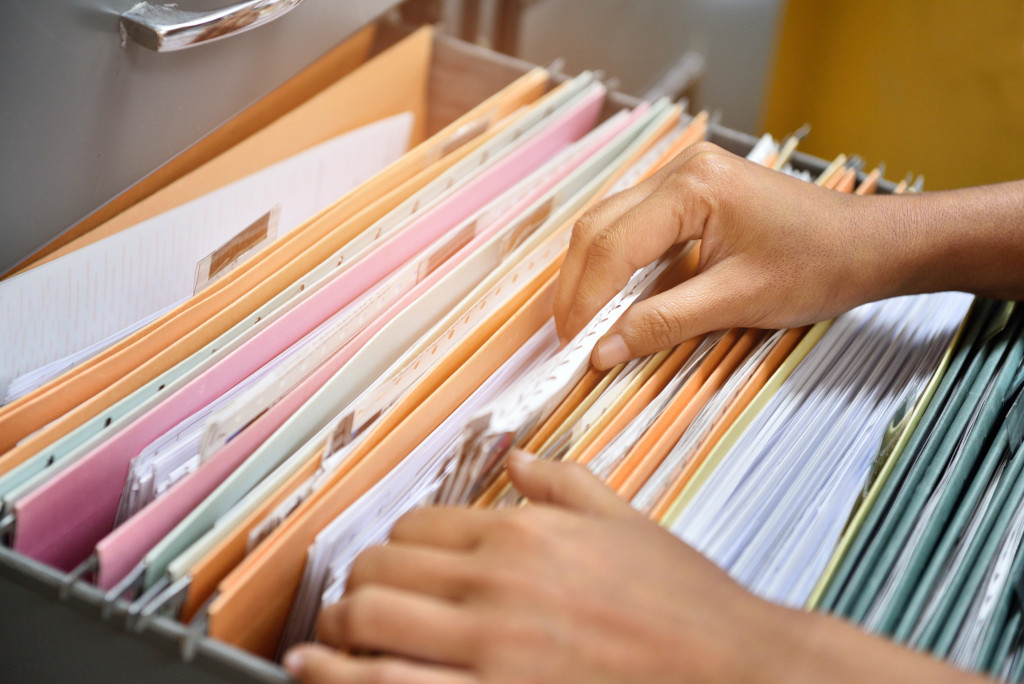 Hand of woman taking file from the box of files 