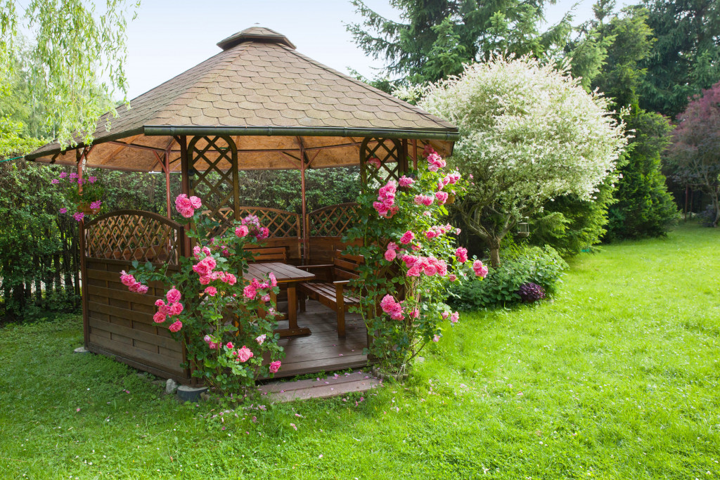 An outdoor wooden gazebo with roses