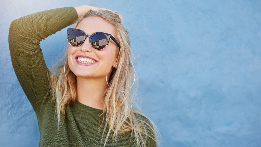 Happy woman in a long sleeve top and sunglasses