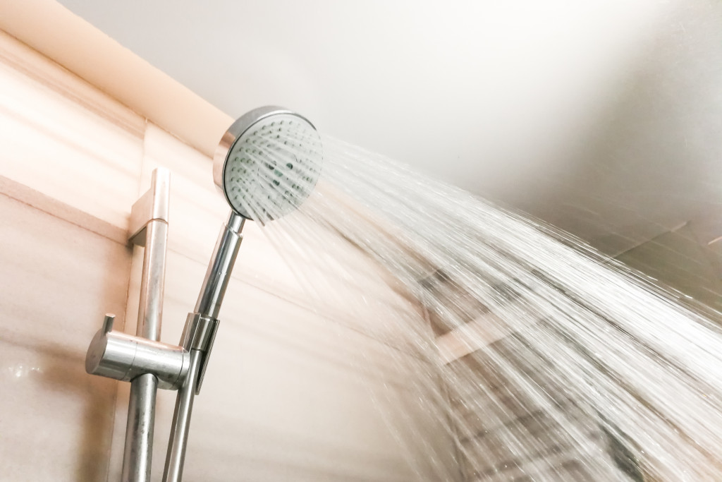 A photo of water running from a showerhead inside the bathroom