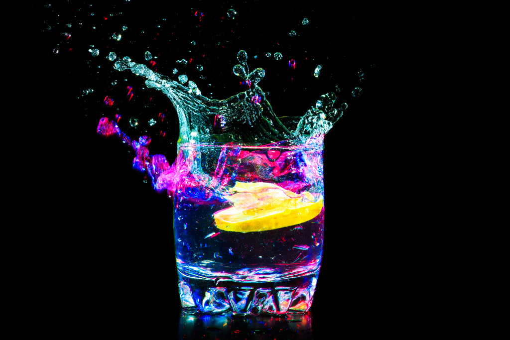 colorful cocktail with lemon slice on black background