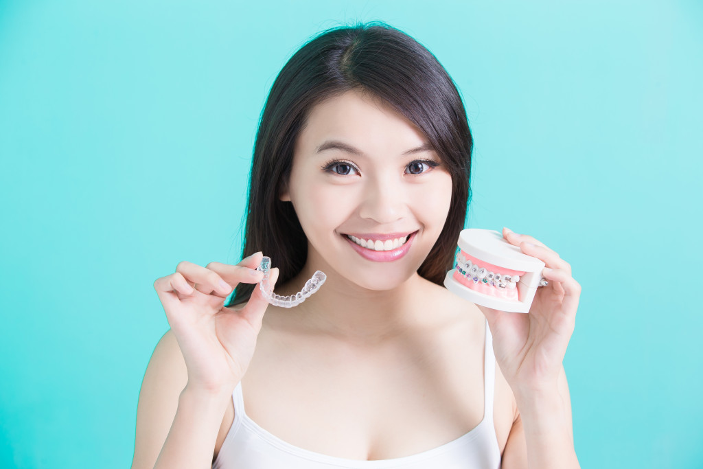 woman holding invisalign with mouth model