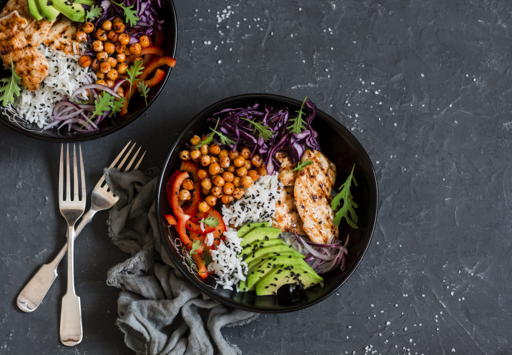 salad with chicken and chickpeas and avocados in black bowl