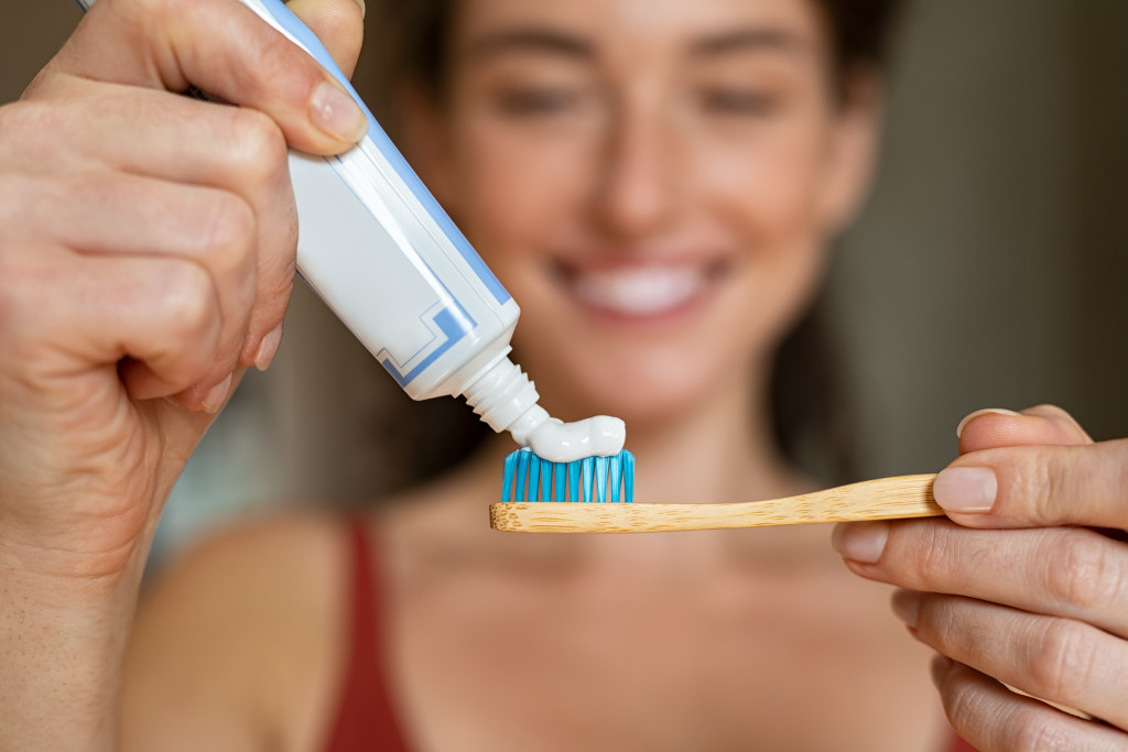 putting toothpaste onto the tooth brush