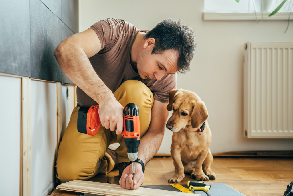 a man doing renovation with dog