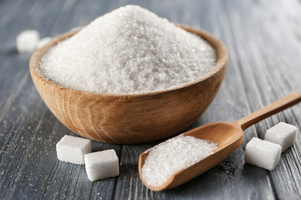 sugar in wooden bowl with sugar cubes