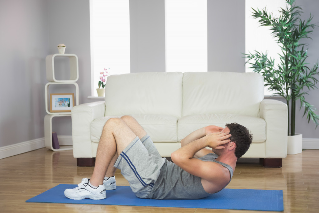 A fit man exercising in a home living room floor