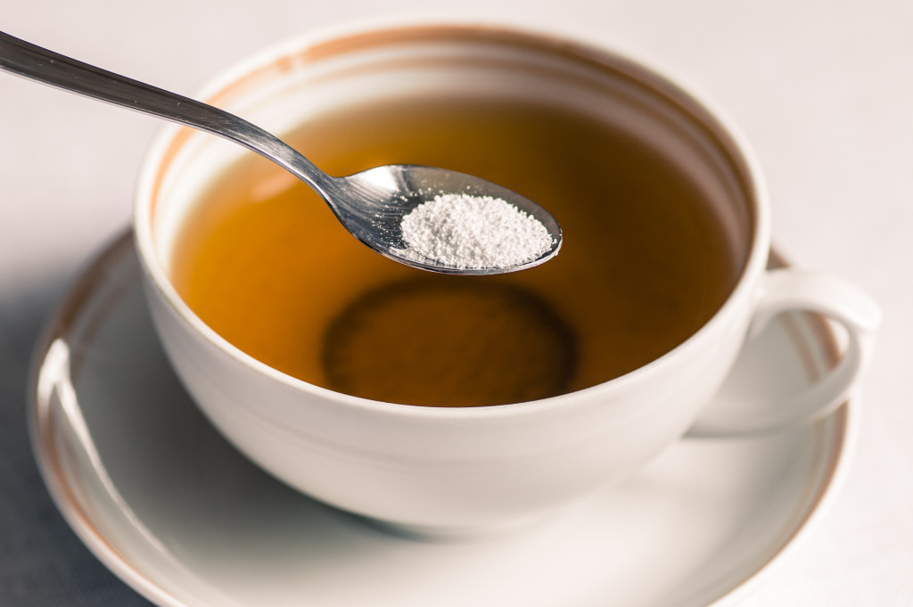 cup of tea with sweetener on spoon