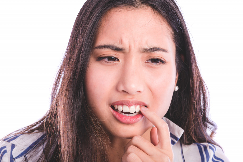 woman suffering from mouth ulcers