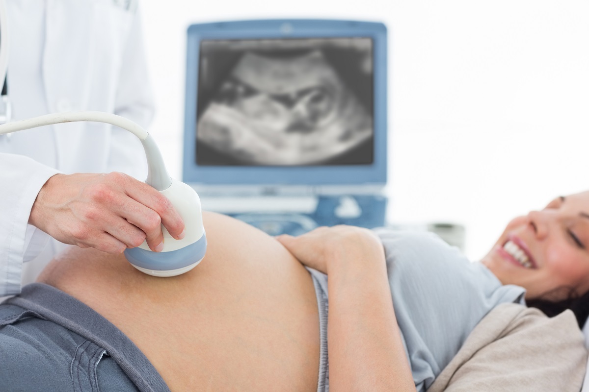 doctor performing ultrasound to a pregnant woman