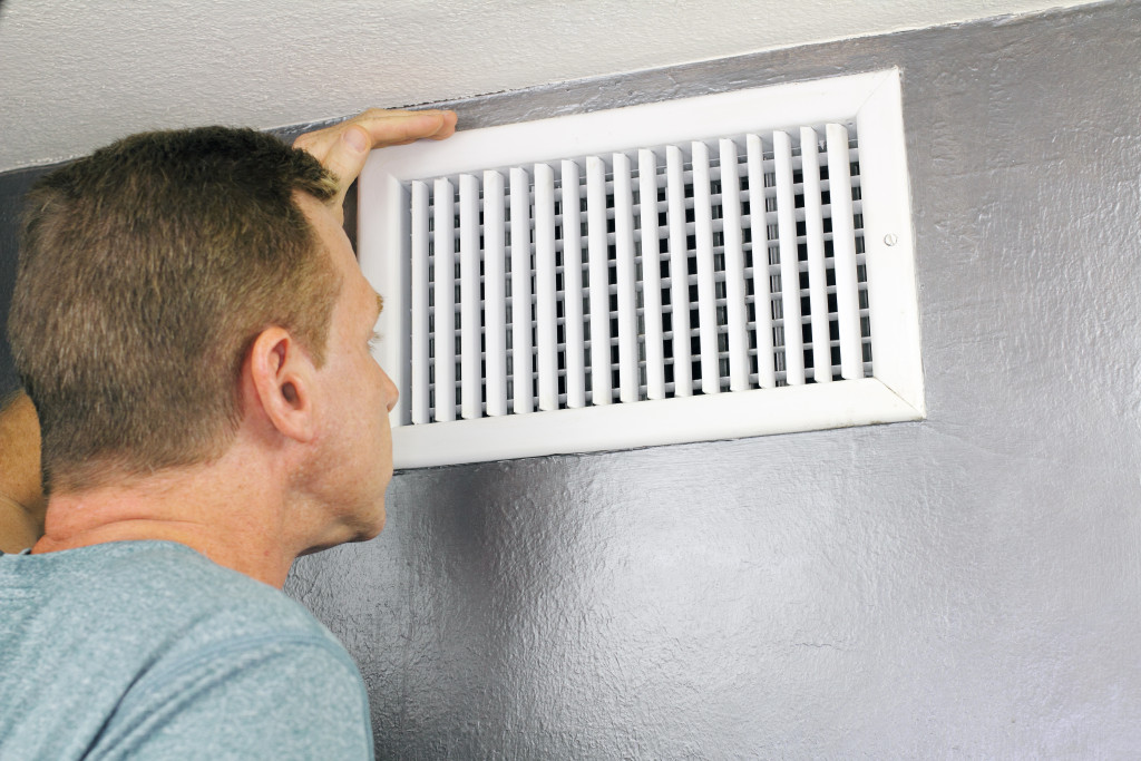 a man examining an outflow air vent