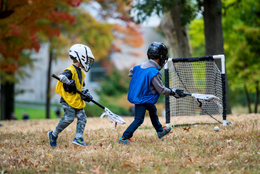 Young children playing field hockey.