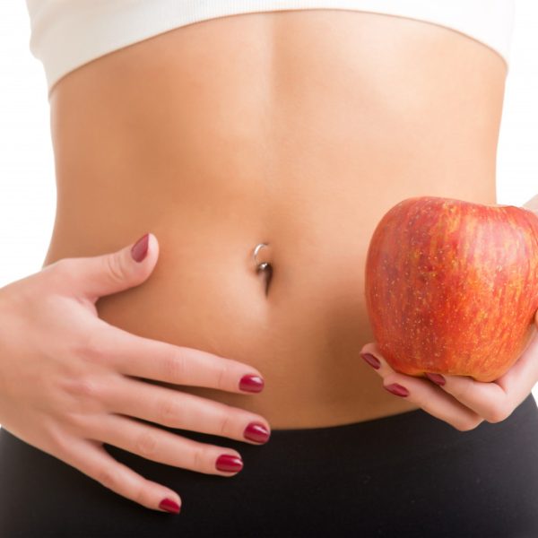stomach of a woman holding an apple